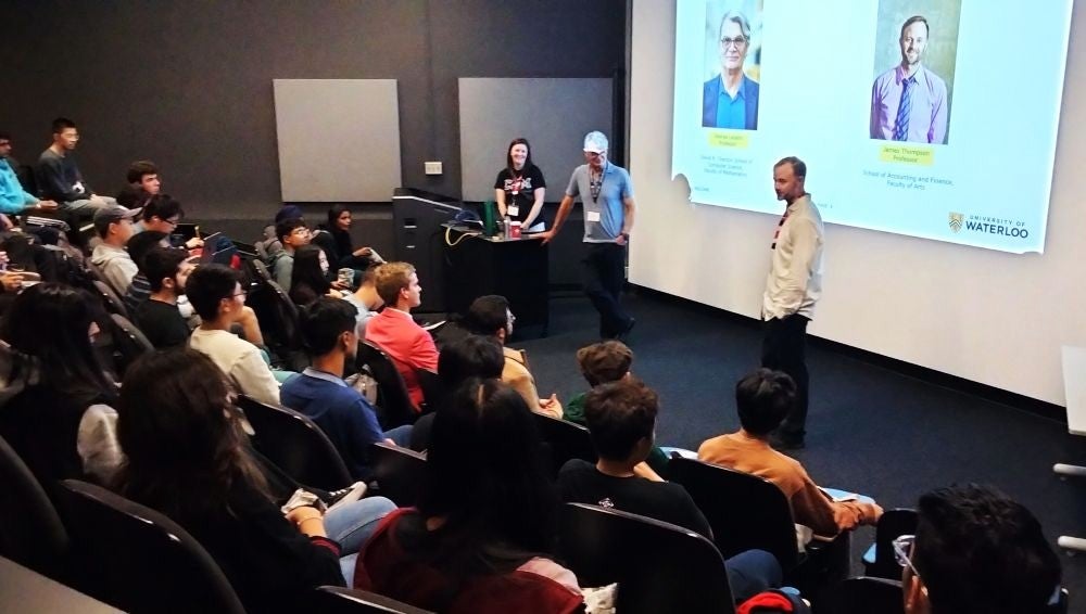 Two professors leading a lecture room of students