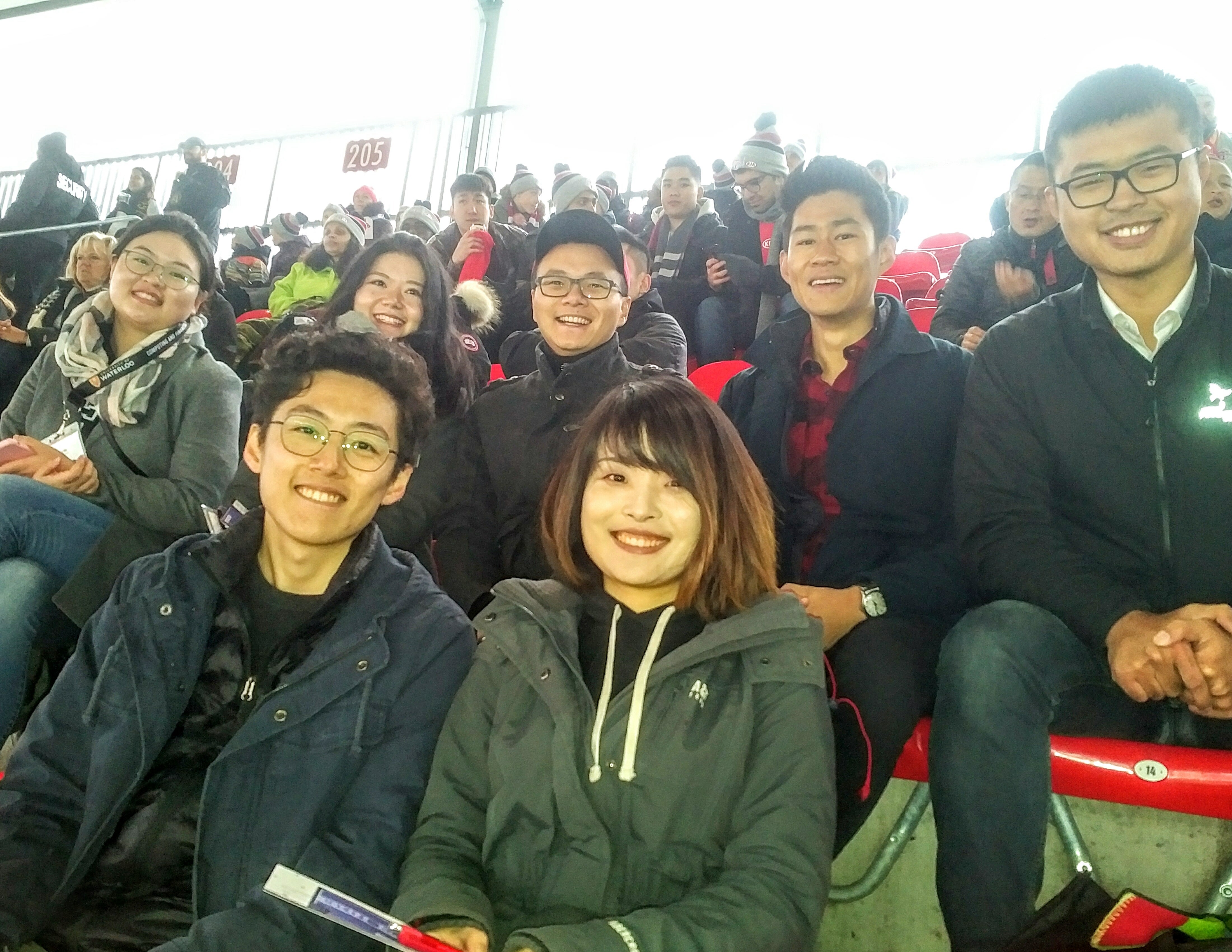 Six alumni cheering in the stands at the Toronto FC soccer match
