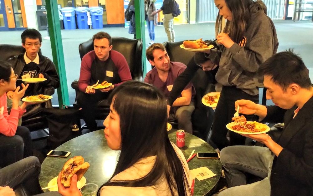 Seven students enjoying food together