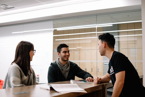 Three undergraduate E Co-op students in the Conrad Hub space chatting