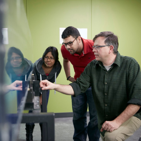 A professor and two Waterloo students working on a problem