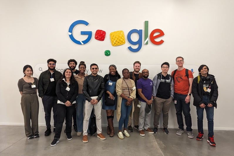 Students pose for group photo under Google logo