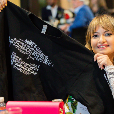 An MBET student proudly shows her #MBETcrew campaign sweater, designed by a fellow student
