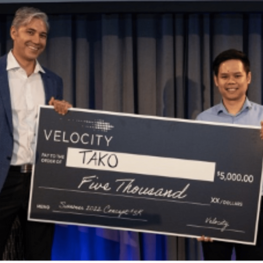 Tony Le, MBET '22, on stage after winning at the Velocity 5K competition, featured in the Spring 2022 competitions roundup