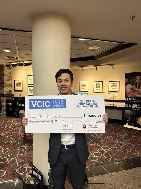 student poses with cheque from VCIC 