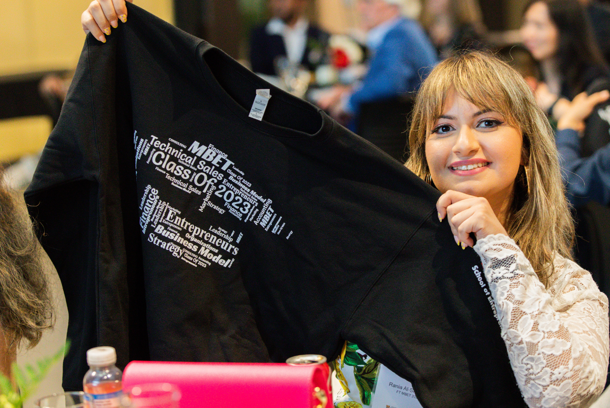 An MBET student proudly shows her #MBETcrew campaign sweater, designed by a fellow student