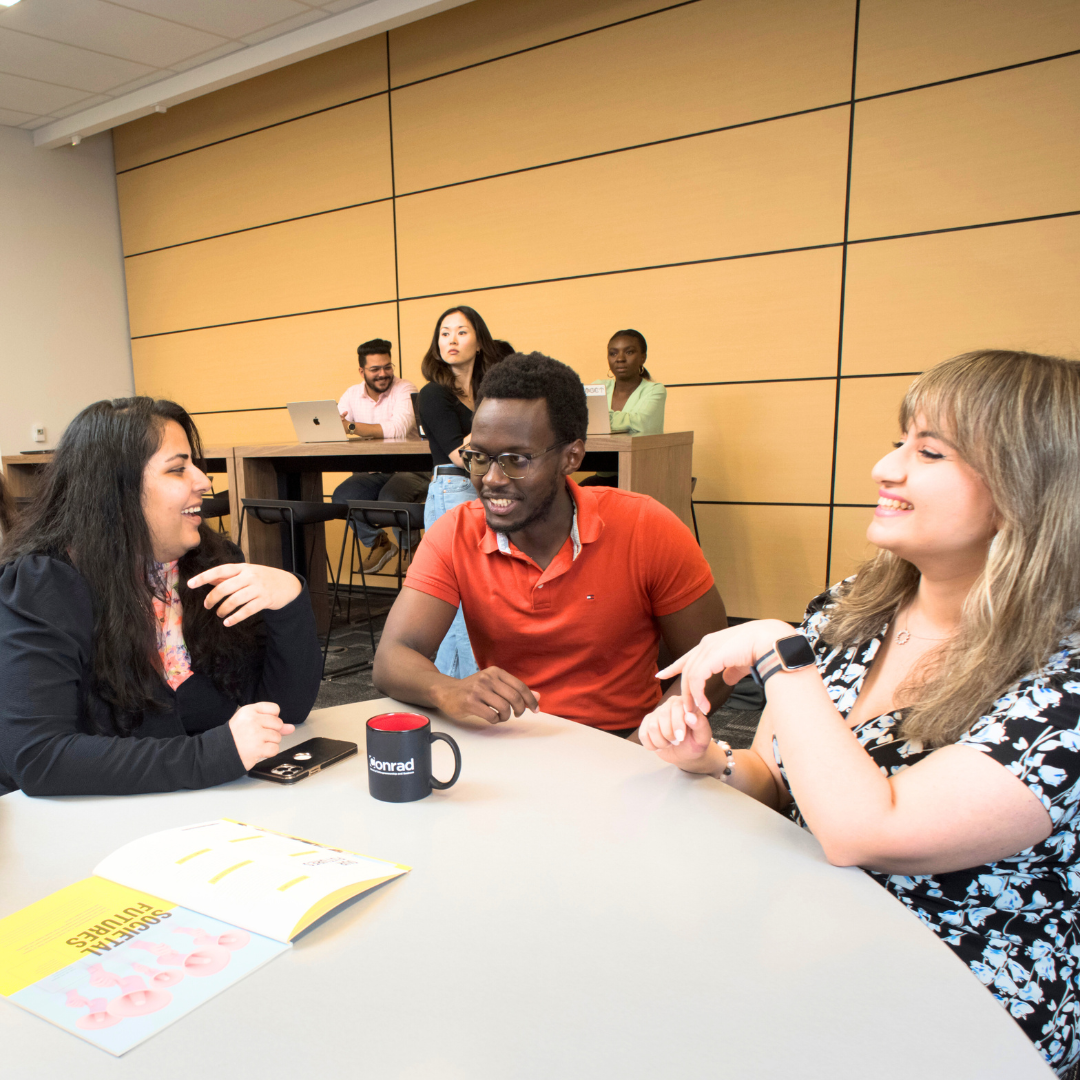 Group of students seated at table in conversation