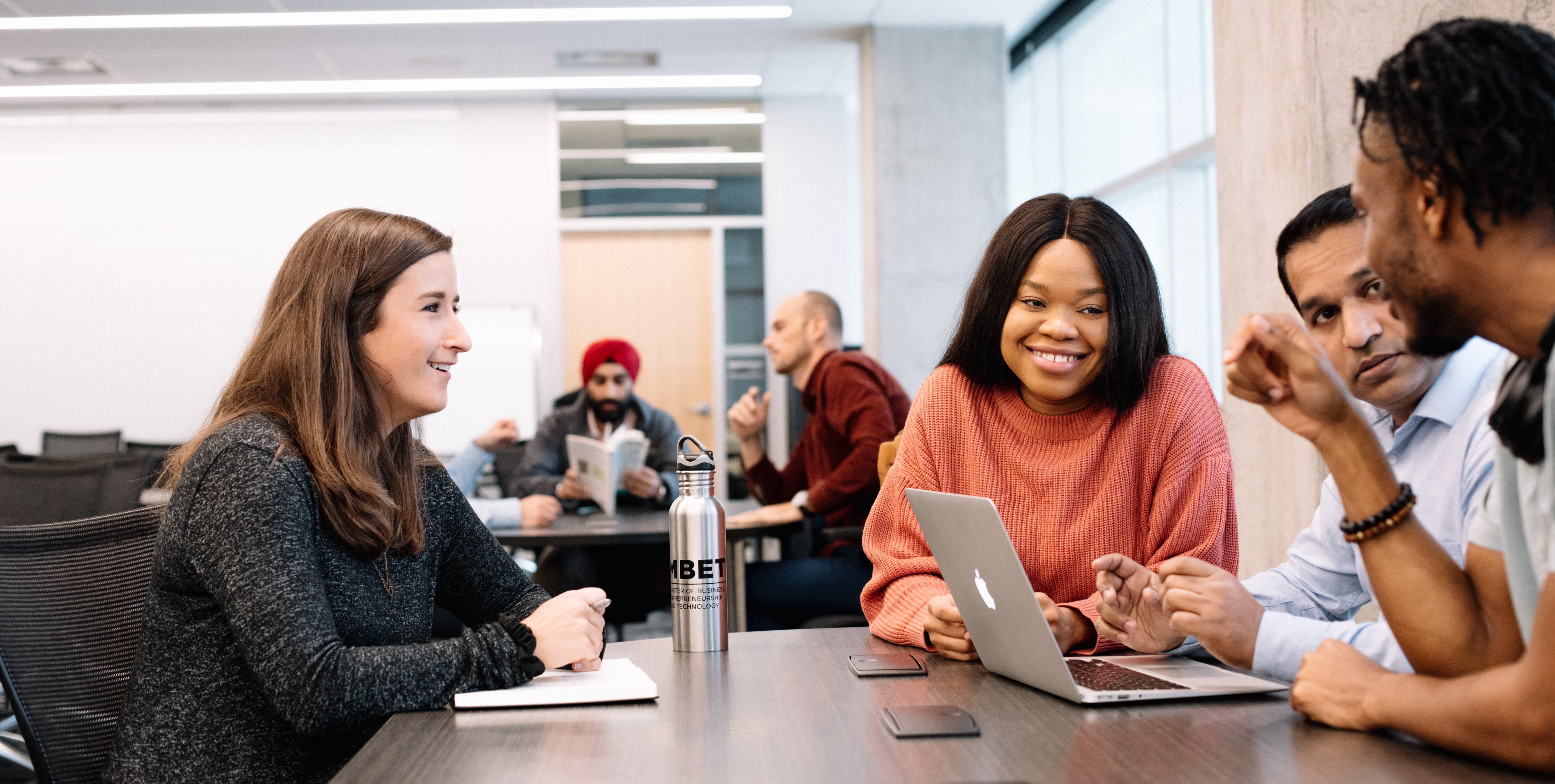 Group of graduate students chatting in the classroom