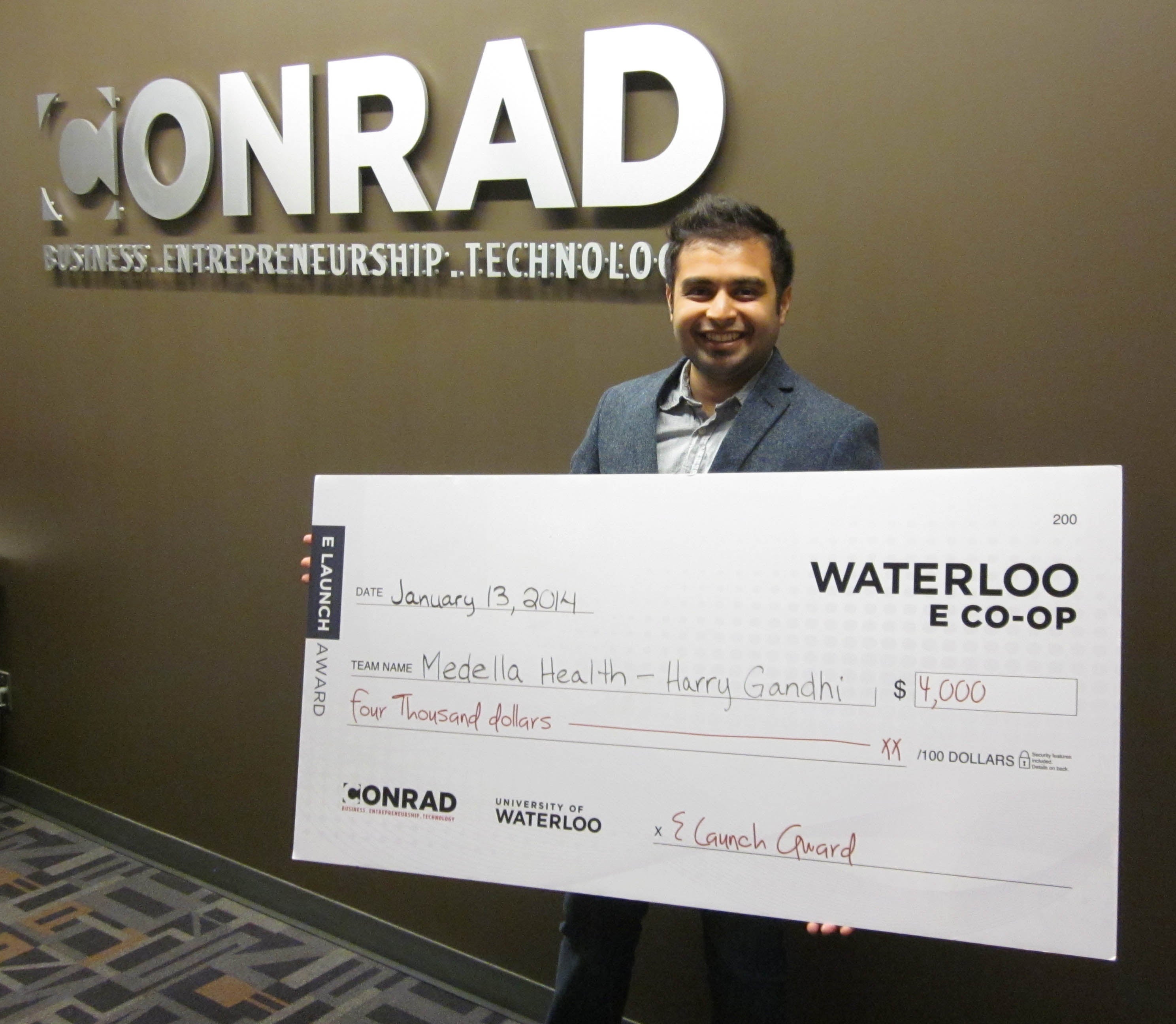 Harry Gandhi holds his $4,000 cheque for Medella Health