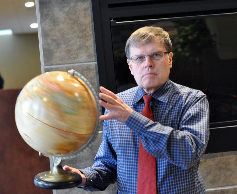 Larry Smith spinning a globe