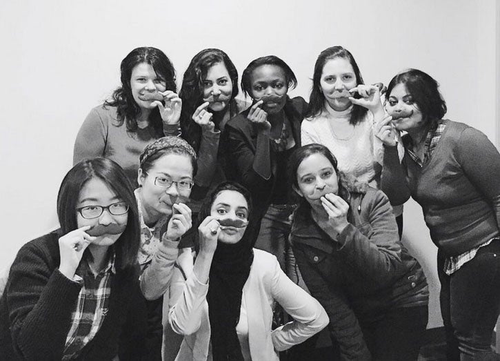 The MBET ladies holding up cookie moustaches