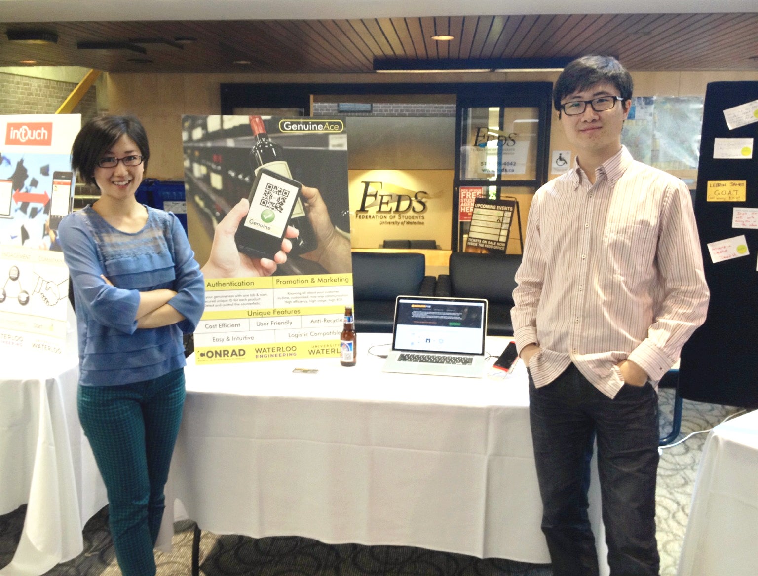 Rachel Huang and Peter Chen with a table, poster and laptop