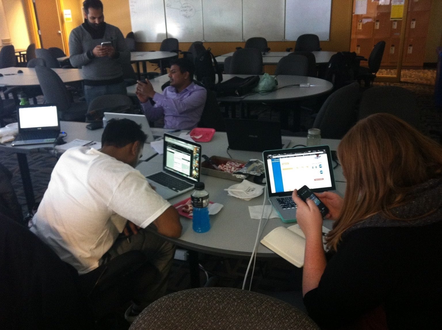 Team members of RBC+ working on their phones and laptops.