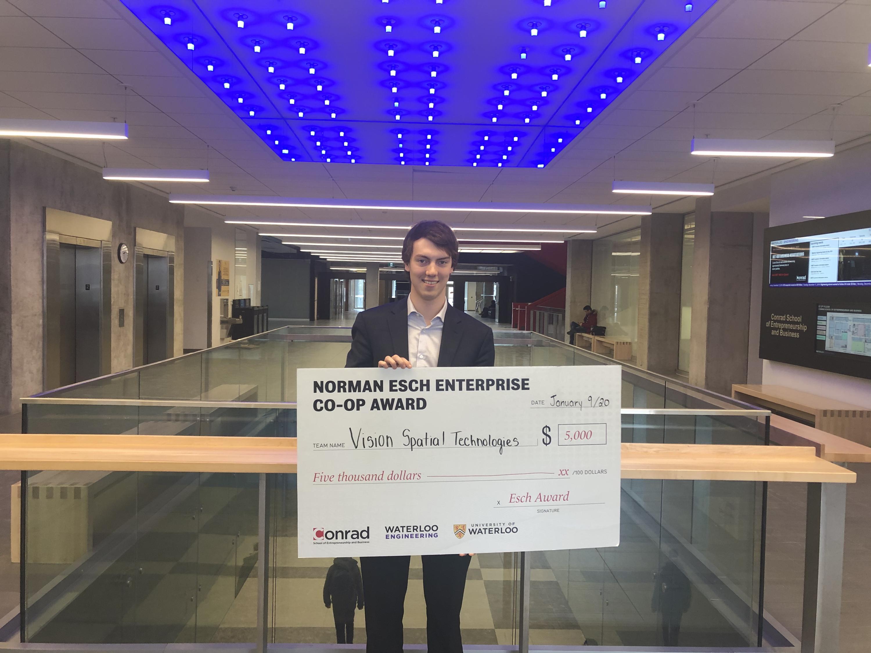Sam Dugan, founder of Vision Spatial Technologies Inc. holds cheque for $5,000