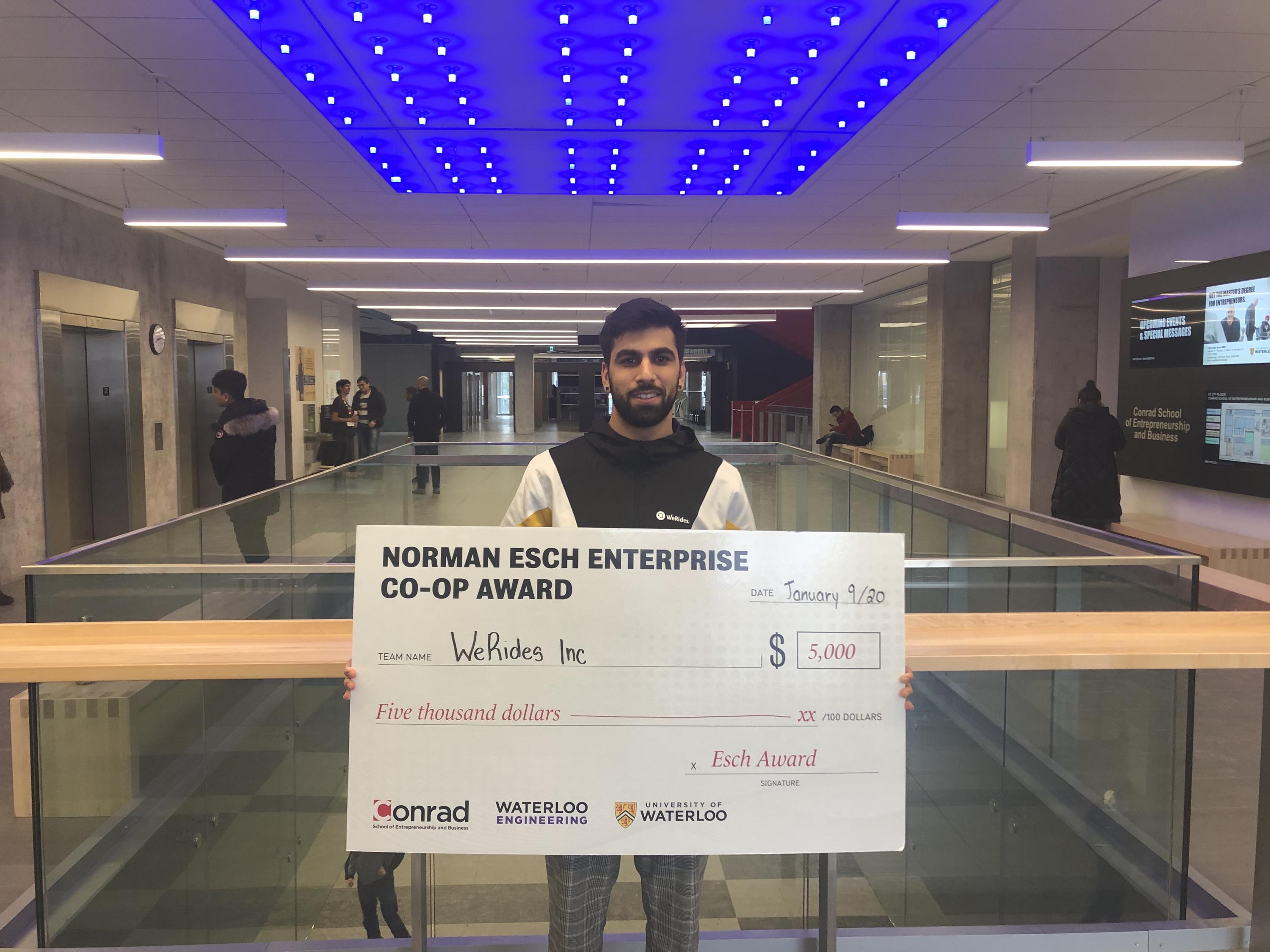 Adil Dharshi, foudner of WeRides Inc. holds cheque for $5,000