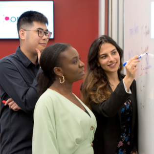 Three Conrad School students working together on their startup