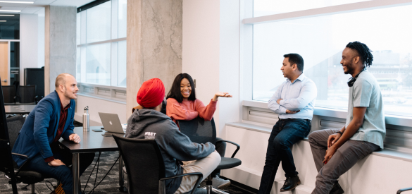 Graduate students sitting around table in casual meeting