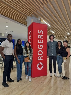 MBET students and alumni stand by Rogers sign with employee