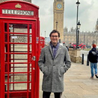 Tyler Cormier standing by red telephone booth