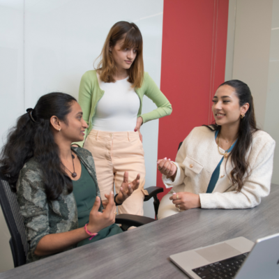 Conrad School undergraduate students discussing a group project
