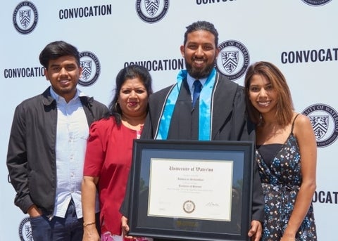 Graduate smiling with guests