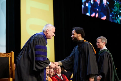 Provost Jim Rush shaking the hand of a graduate