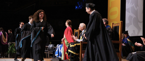 Graduation student walking across the convocation stage