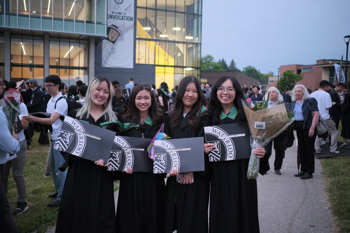 Grads holding their diplomas