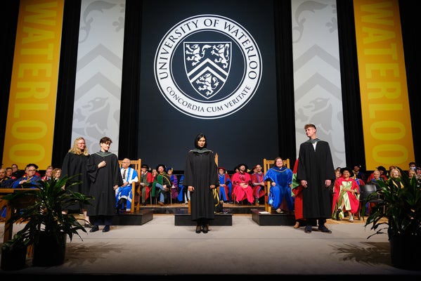 Three graduates on stage at convocation