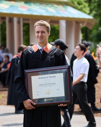 Graduate holding his framed degree