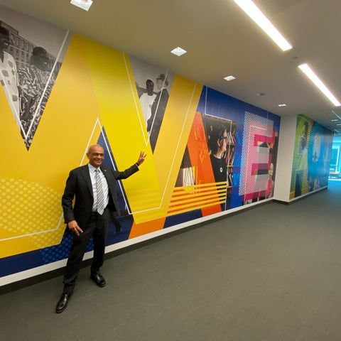 President Goel posing in front of the mural