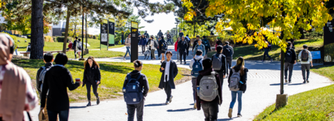 Multiple students walking on the main path on campus