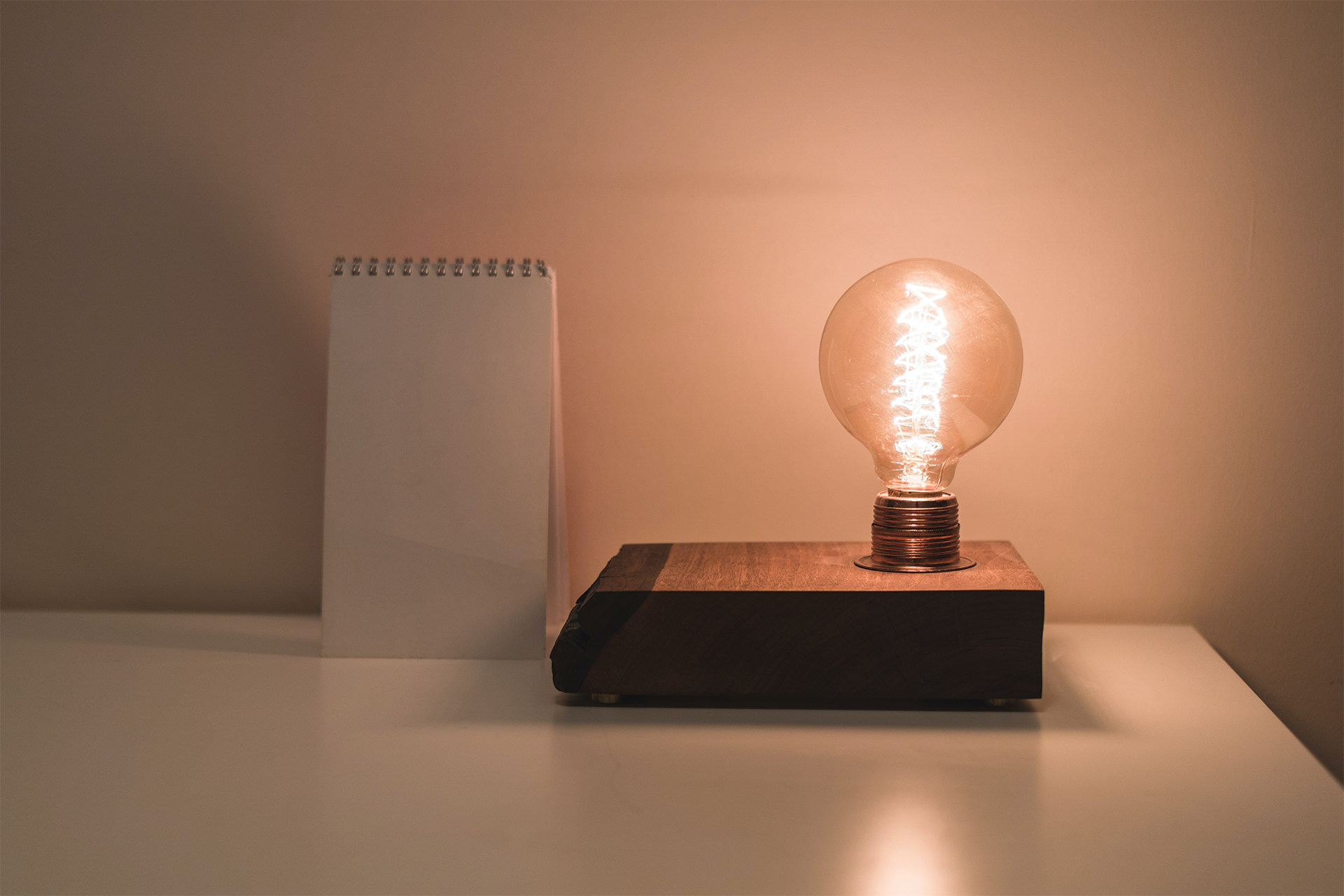 A lit lightbulb on a desk.