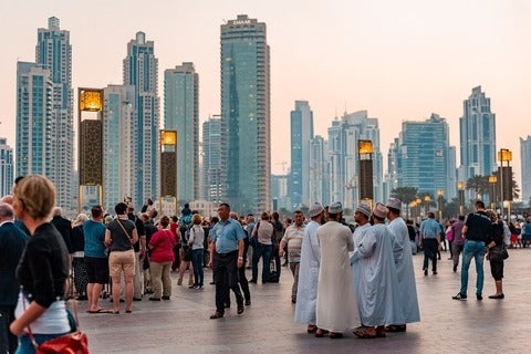 Large crowd in Arabic city - skyline can be seen in background