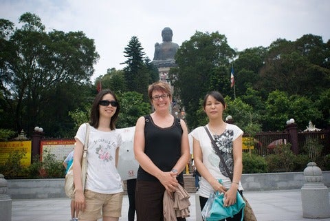 Dr. Adair and two graduate students standing in front of the Tian Tan Buddha statue of Po Lin Monastery
