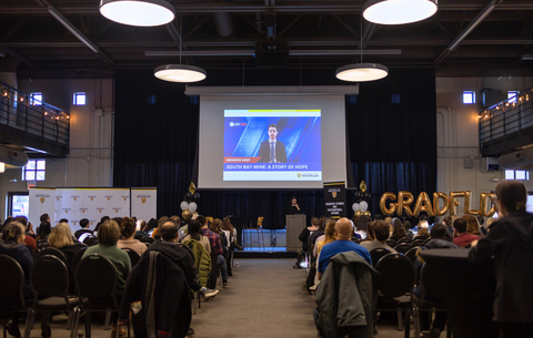 Audience watches GRADflix video at showcase event