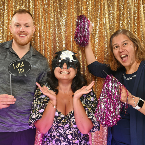 Student and supervisor posing in the photobooth with pompoms