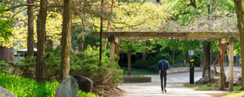 Student walking in Peter Russell rock garden