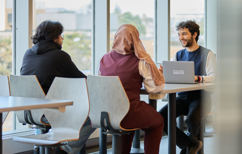 Students working at a table with a laptop - 1920 x 1220