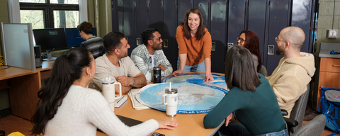 Students working together at a table with a map