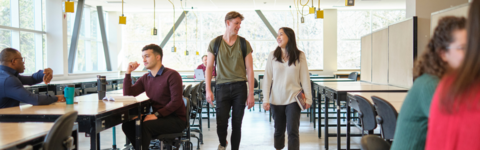 Two students walking indoors