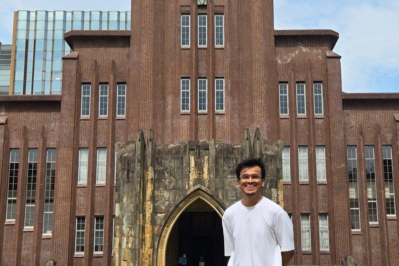 Rishabh Bajaj standing in front of a tall building with a clock at the top.