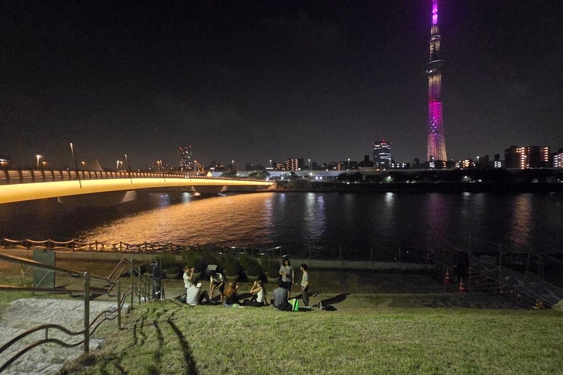 A river with a tall building in the background at nighttime