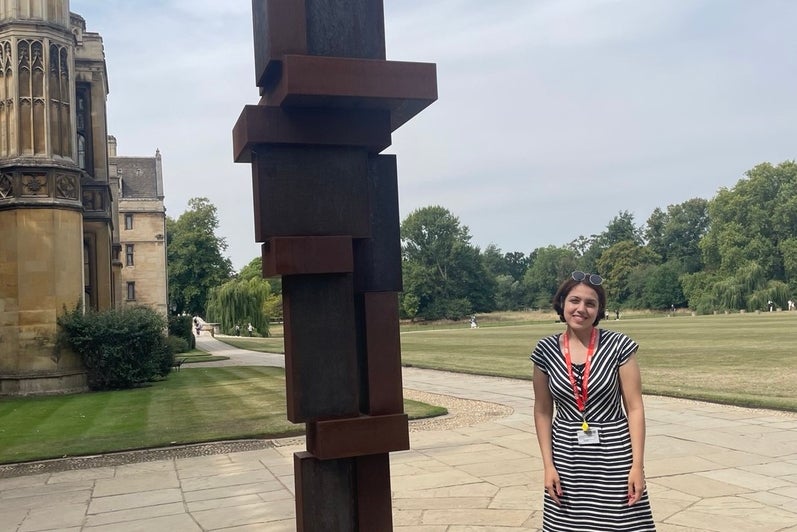 Atiyeh Ahmadi standing beside a sculpture