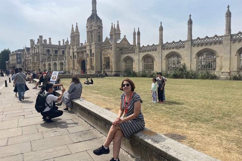 Atiyeh Ahmadi sitting in front of historic looking building