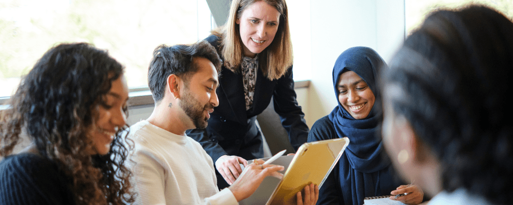Group of students getting help from professor
