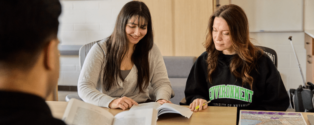 Students sitting at a table looking at a book
