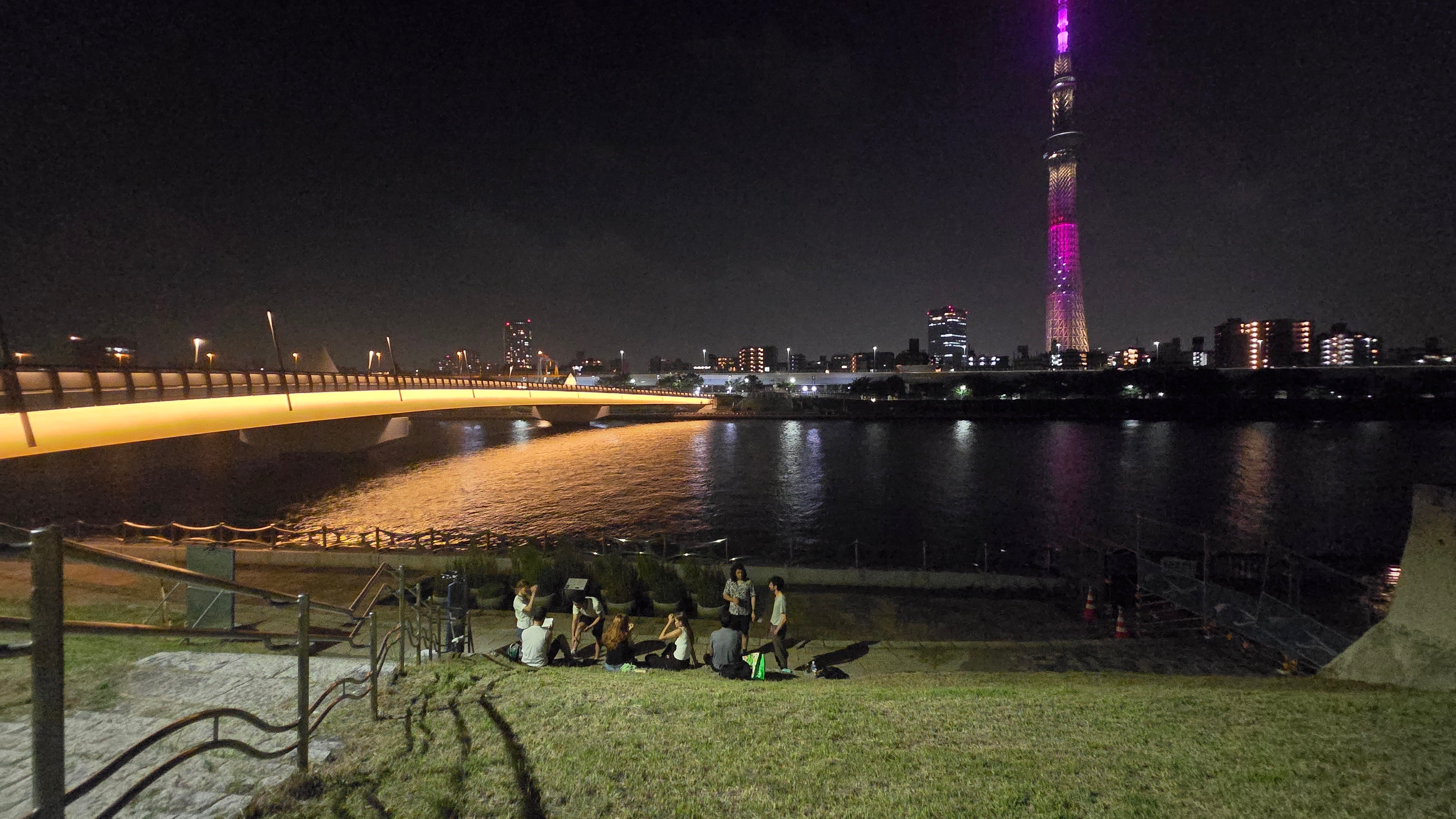 A river with a tall building in the background at nighttime