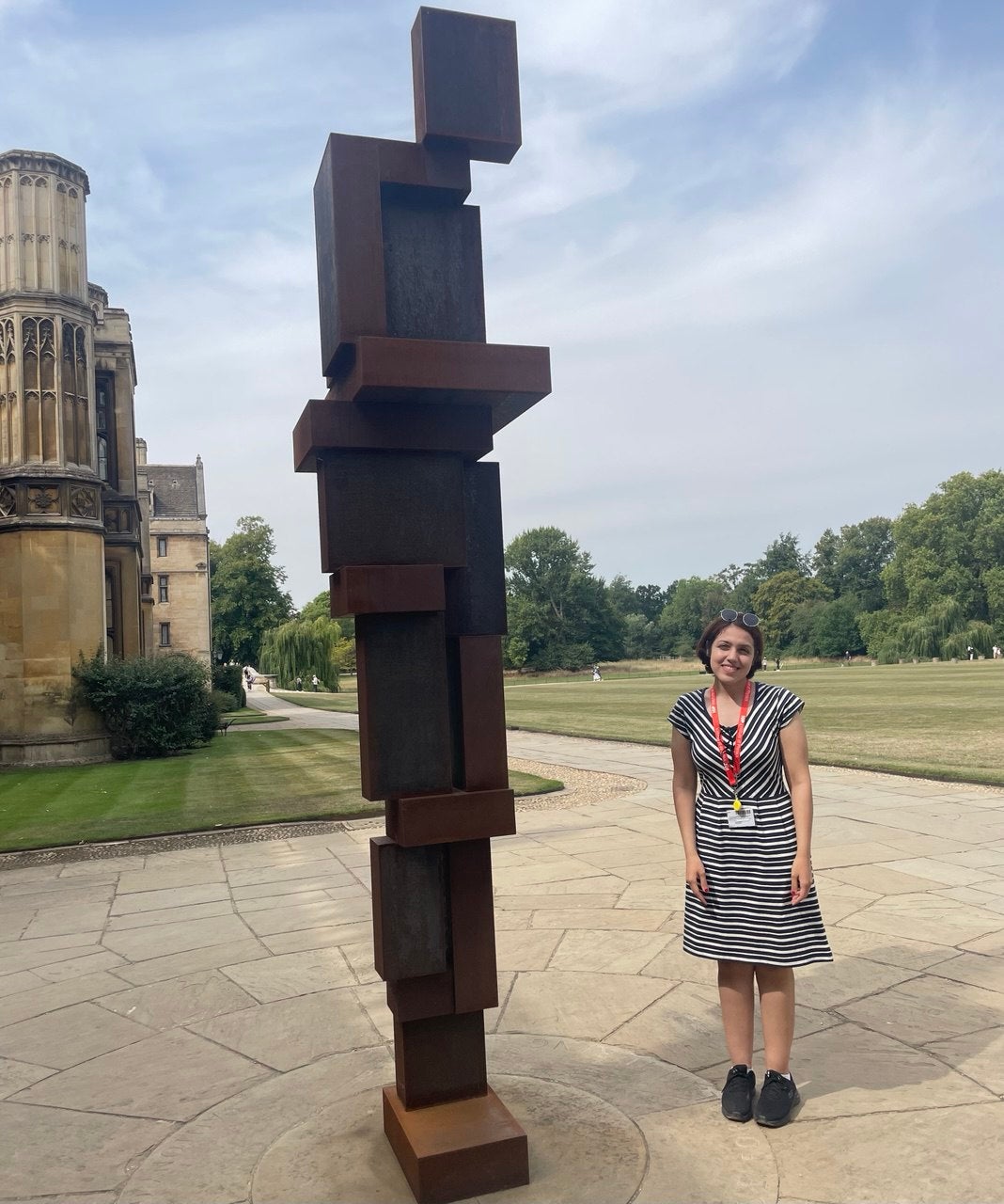 Atiyeh Ahmadi standing beside a sculpture