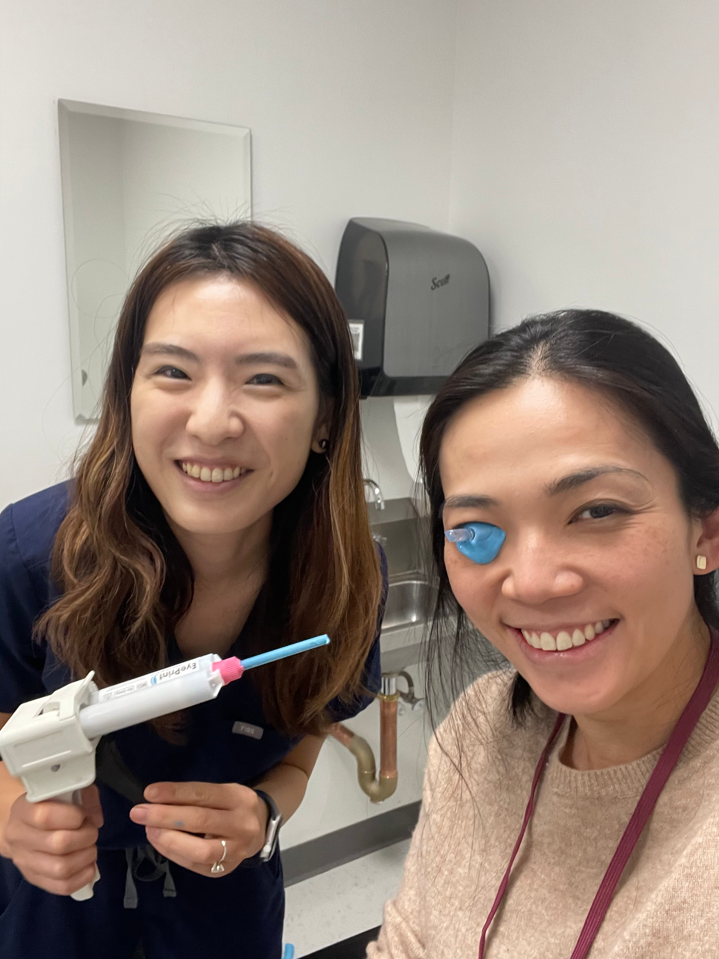 Sharon Qiu smiling with an eye mold in her eye